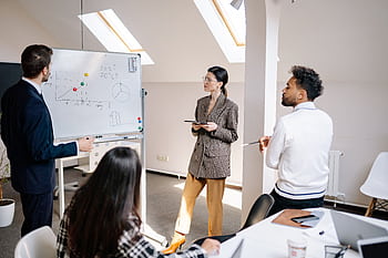 Professionals engaged in a collaborative team meeting with charts for strategy planning. HD wallpaper