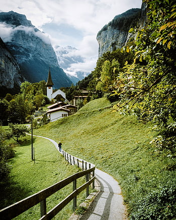 Idyllic summer scene with mountain backdrop and pathway in a lush valley. HD phone wallpaper