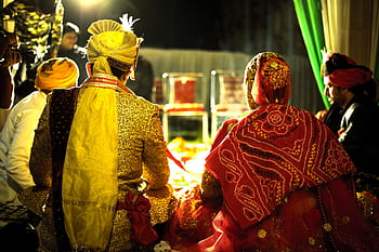 Colorful Indian bride and groom at a traditional wedding ceremony during the night. HD wallpaper