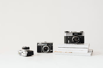 Three vintage cameras displayed on a white background, emphasizing nostalgia and retro design. HD wallpaper