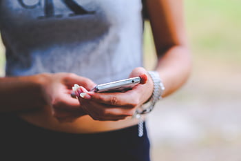 Close-up of a woman texting on a smart outdoors, emphasizing mobile connectivity and technology. HD wallpaper