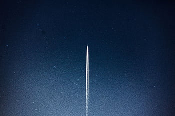 A rocket streaks through a starry night, leaving a trail in outer space. HD wallpaper