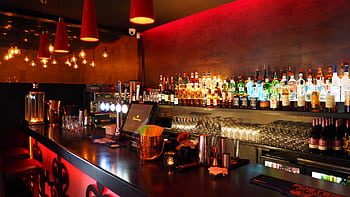Enjoy the warm ambiance of a well-stocked, illuminated bar perfect for nightlife and celebrations. HD wallpaper