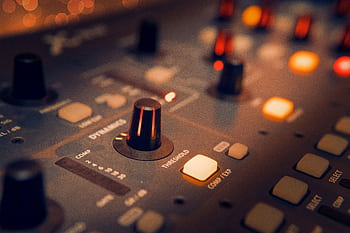 A detailed view of an audio mixer with glowing knobs, perfect for music production themes. HD wallpaper