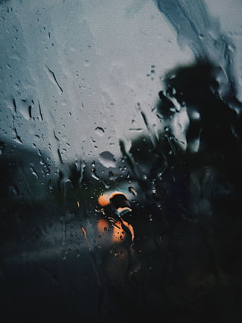 Raindrops on a window with blurred street lights creating a moody scene. HD phone wallpaper