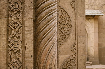 Detailed view of Islamic stone carvings showcasing ornate geometric patterns and motifs. HD wallpaper