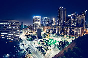 Aerial view of city skyscrapers and streets illuminated at night, capturing the vibrant urban skyline. HD wallpaper