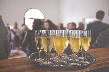 A sophisticated event with champagne glasses at a lively social gathering indoors. HD wallpaper