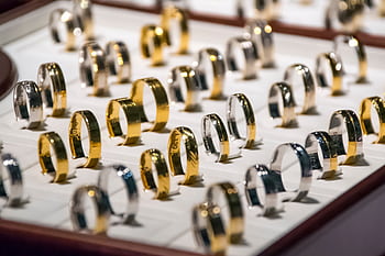 A luxurious display of gold and silver rings, perfect for showcasing jewelry collections. HD wallpaper