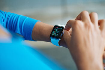 Person interacting with a smartwatch, showing a fitness application on the screen. HD wallpaper