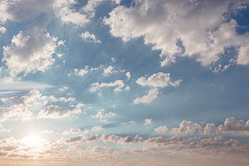 Beautiful sky with scattered clouds and sunlight streaming through, perfect for backgrounds. HD wallpaper