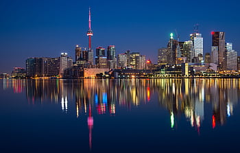 Stunning night view of Toronto skyline reflecting on water with CN Tower prominent. HD wallpaper