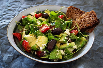 Delicious Greek salad featuring avocado, feta, and olives, ideal for a healthy meal. HD wallpaper