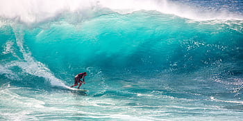 Thrilling surfing on massive turquoise waves, capturing the essence of ocean sports and adventure. HD wallpaper