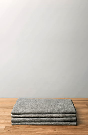 Minimalist of a folded gray wool blanket on a wooden table against a neutral backdrop. HD phone wallpaper