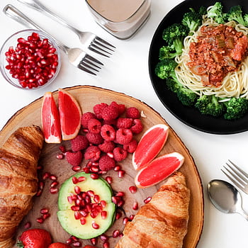 A vibrant breakfast spread with croissants, pasta, and fresh fruits, perfect for food lovers. HD phone wallpaper
