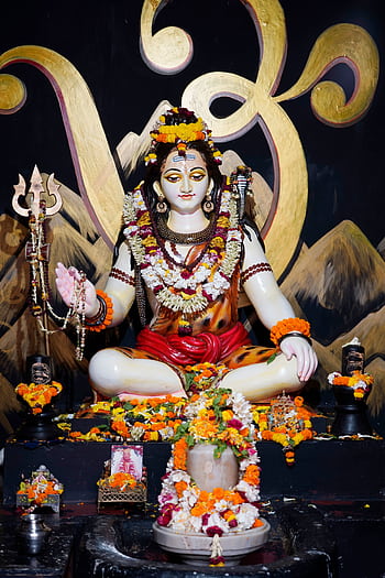 Vibrant sculpture of a Hindu deity adorned with flowers, symbolizing spirituality. HD phone wallpaper