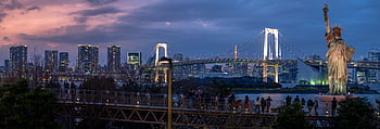 Panoramic view of Tokyo with the illuminated Rainbow Bridge and replica Statue of Liberty at dusk. HD wallpaper