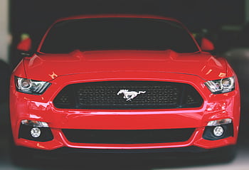 Bright red Ford Mustang showcased with a sleek front view in Ahmedabad. HD wallpaper