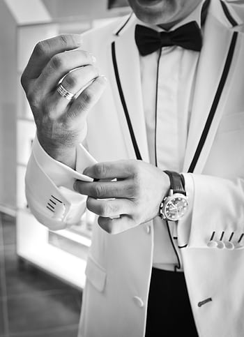 Black and white of a man in a tuxedo adjusting cufflinks, emphasizing formal elegance. HD phone wallpaper