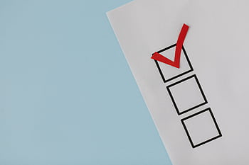 A simple white paper checklist with one red checkmark, ideal for concepts like completion or approval. HD wallpaper