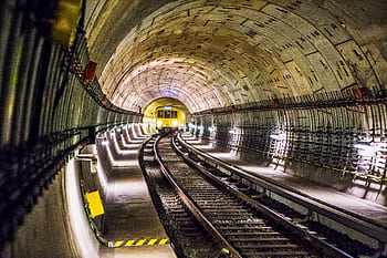 Dramatic view of a Berlin subway tunnel with train approaching, showcasing modern infrastructure. HD wallpaper