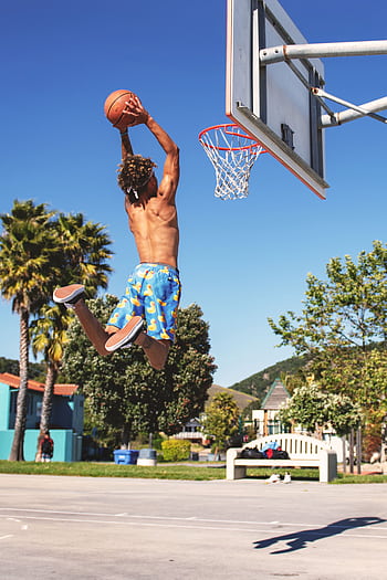 Shirtless man performing a basketball dunk at outdoor court in summer. HD phone wallpaper