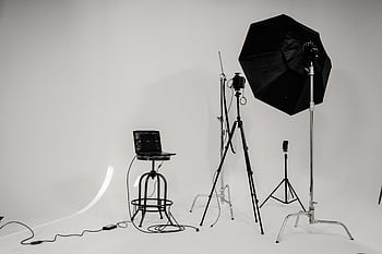 A black and white of a well-equipped graphy studio with lighting equipment and tripods. HD wallpaper