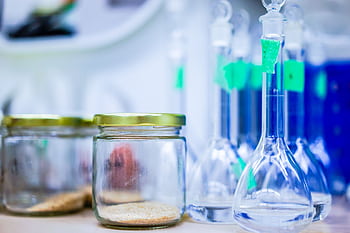 A close-up view of laboratory glassware and jars, used for scientific experiments. HD wallpaper