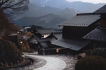 Scenic view of a traditional Japanese village nestled in the mountains during twilight. HD wallpaper