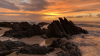 Stones Rocks Beach Sand Ocean Waves Under Black Clouds Blue Sky During Sunset Nature HD wallpaper