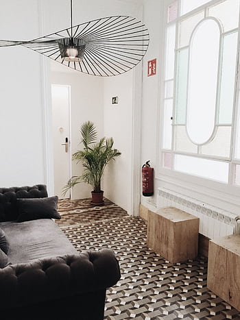 Elegant living room with geometric flooring, plush sofa, and tasteful decor. HD phone wallpaper
