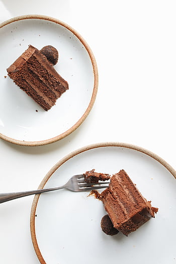 Indulgent chocolate cake slices served on ceramic plates with a fork. HD phone wallpaper