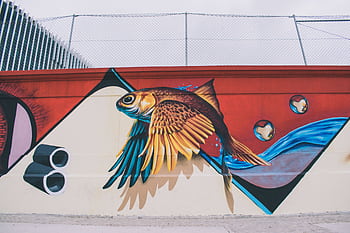 Vibrant fish mural capturing creativity and street art on an urban wall. HD wallpaper
