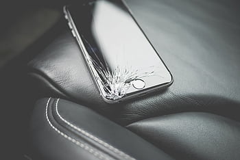 Close-up of a broken smart with a cracked screen on a leather car seat. HD wallpaper