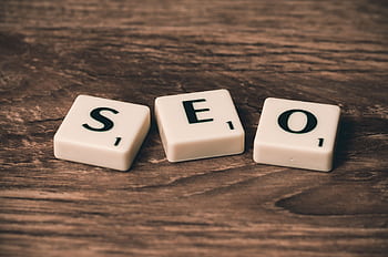 Scrabble tiles spelling 'SEO' on a wooden surface. Ideal for digital marketing themes. HD wallpaper