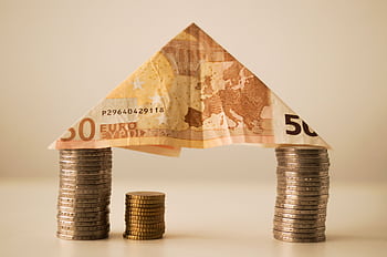 A creative composition using euro banknotes and coins to represent savings and financial structure. HD wallpaper
