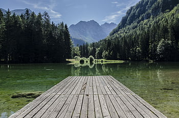 Tranquil lake scene with mountains and dock in Kranj, Slovenia. HD wallpaper