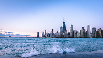 Explore the iconic Chicago skyline at dusk with a stunning waterfront view and splashing waves. HD wallpaper