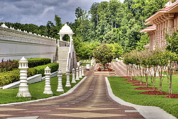 Peaceful garden view showcasing ornate architecture and lush greenery on a sunny day. HD wallpaper