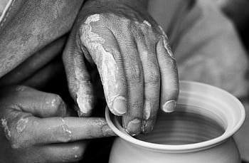 Artistic black and white close-up of hands shaping clay pottery on a wheel. HD wallpaper