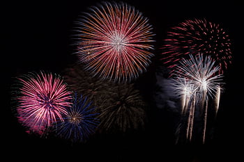 A stunning fireworks display lights up the night sky with vibrant colors. HD wallpaper