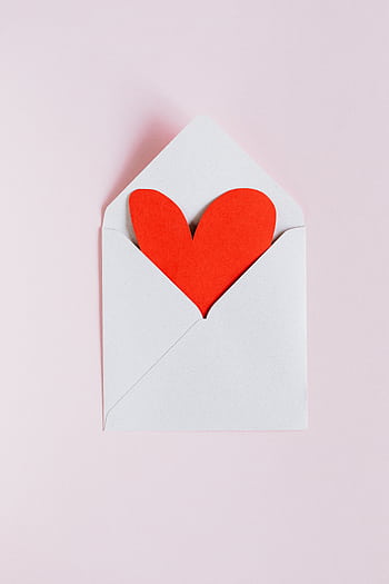 A red heart inside an open envelope on a soft pink backdrop, symbolizing love and romance. HD phone wallpaper