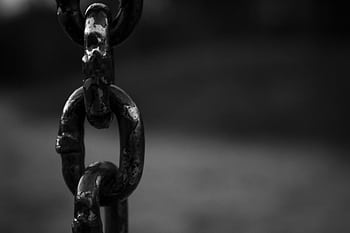 Detailed black and white of a rusty chain link with blurred background. HD wallpaper