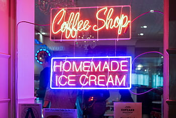 Vibrant neon signs for a coffee shop and homemade ice cream displayed indoors. HD wallpaper