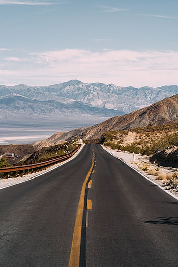 A que highway winding through a desert landscape with distant mountains in the background. HD phone wallpaper