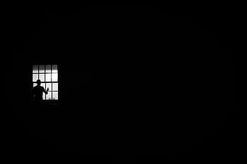 A solitary silhouette at a window against a black and white backdrop, evoking isolation and mystery. HD wallpaper