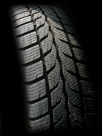 Detailed close-up of a rubber tire showcasing texture and tread pattern, ideal for design concepts. HD phone wallpaper