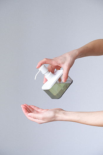 Close-up of a person applying liquid soap for hand hygiene. Indoors, bright lighting. HD phone wallpaper