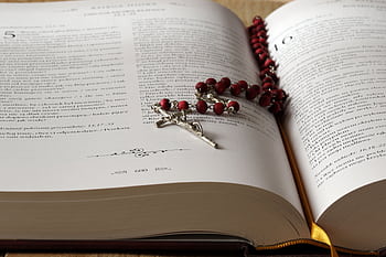 Open Bible with red rosary beads draped on pages, symbolizing faith and devotion. HD wallpaper